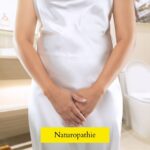femme en robe blanche les mains devant l'entre-jambes illustrant les infections urinaires et les cystites
